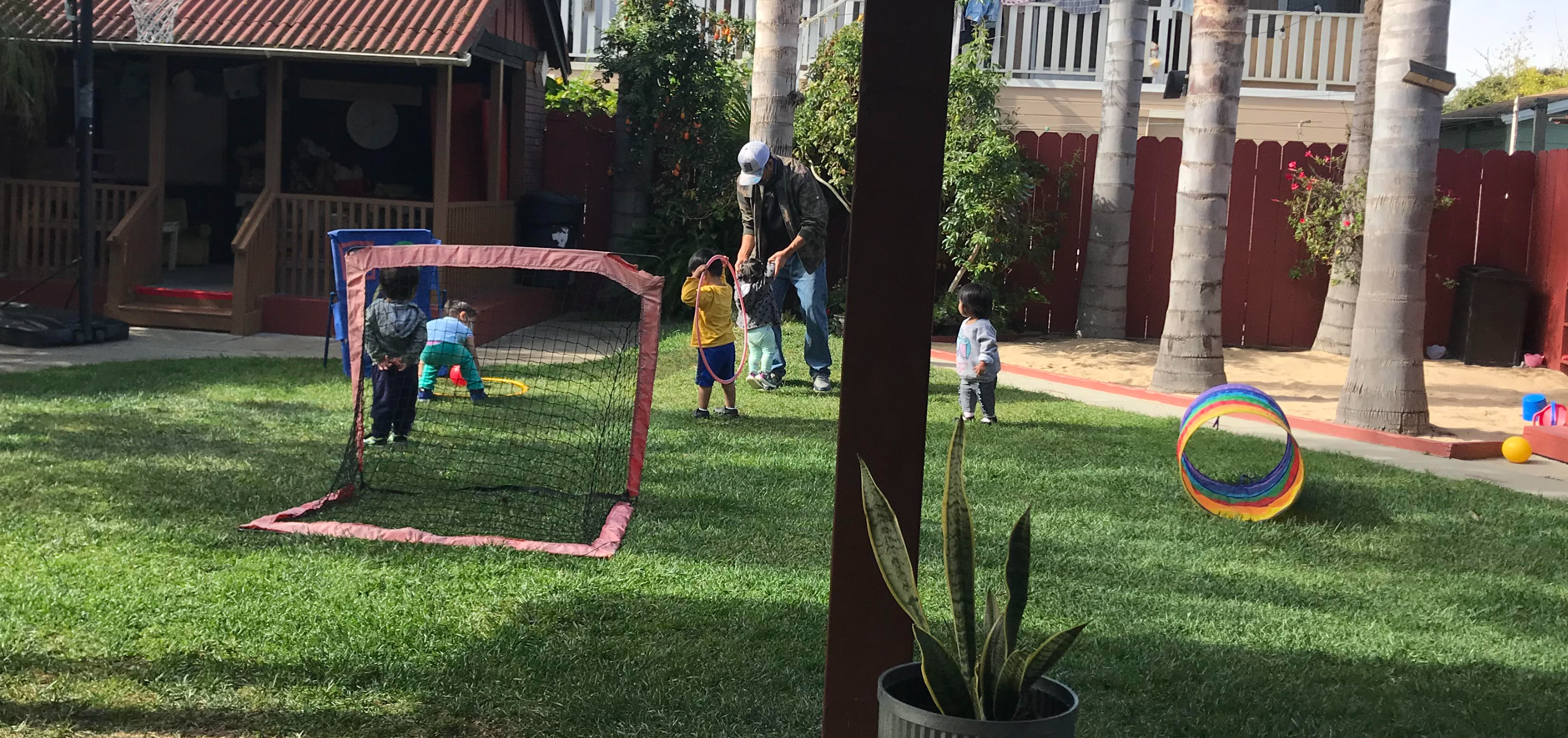 adult and children in backyard playing on the grass